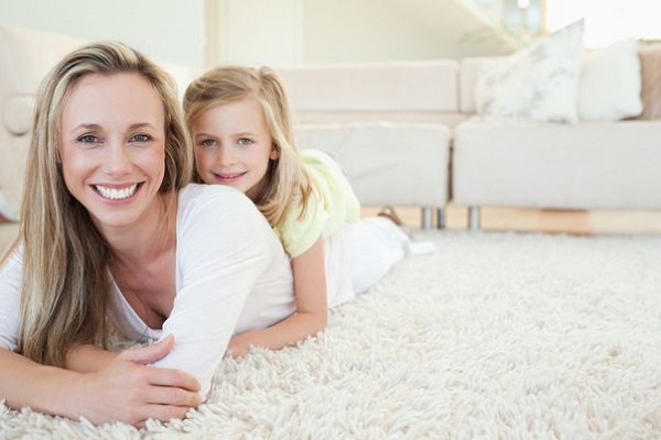 девочка с мамой лежат на чистом ковре