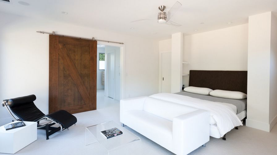 Minimalist bedroom featuring a siding barn door