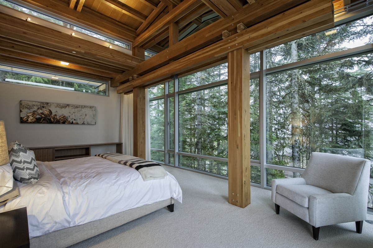 Интерьер спальни в загородном доме с панорамными окнами