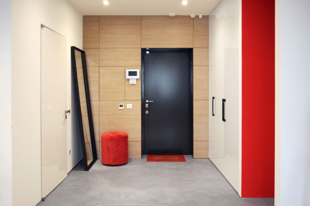 Красный пуф воле входной двери черного цвета