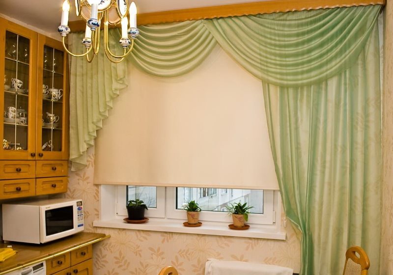 Бежевая рулонная штора на окне кухни с зеленым ламбрекеном