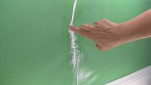 photo smoothing caulk into a plaster wall crack